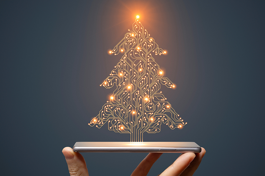 Christmas Tree concept with hand holding smartphone on dark